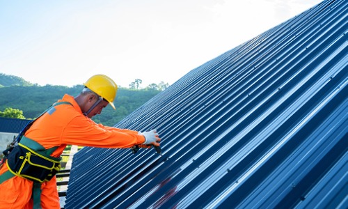 A contractor working on a metal roof during Commercial Roof Repair in Phoenix AZ